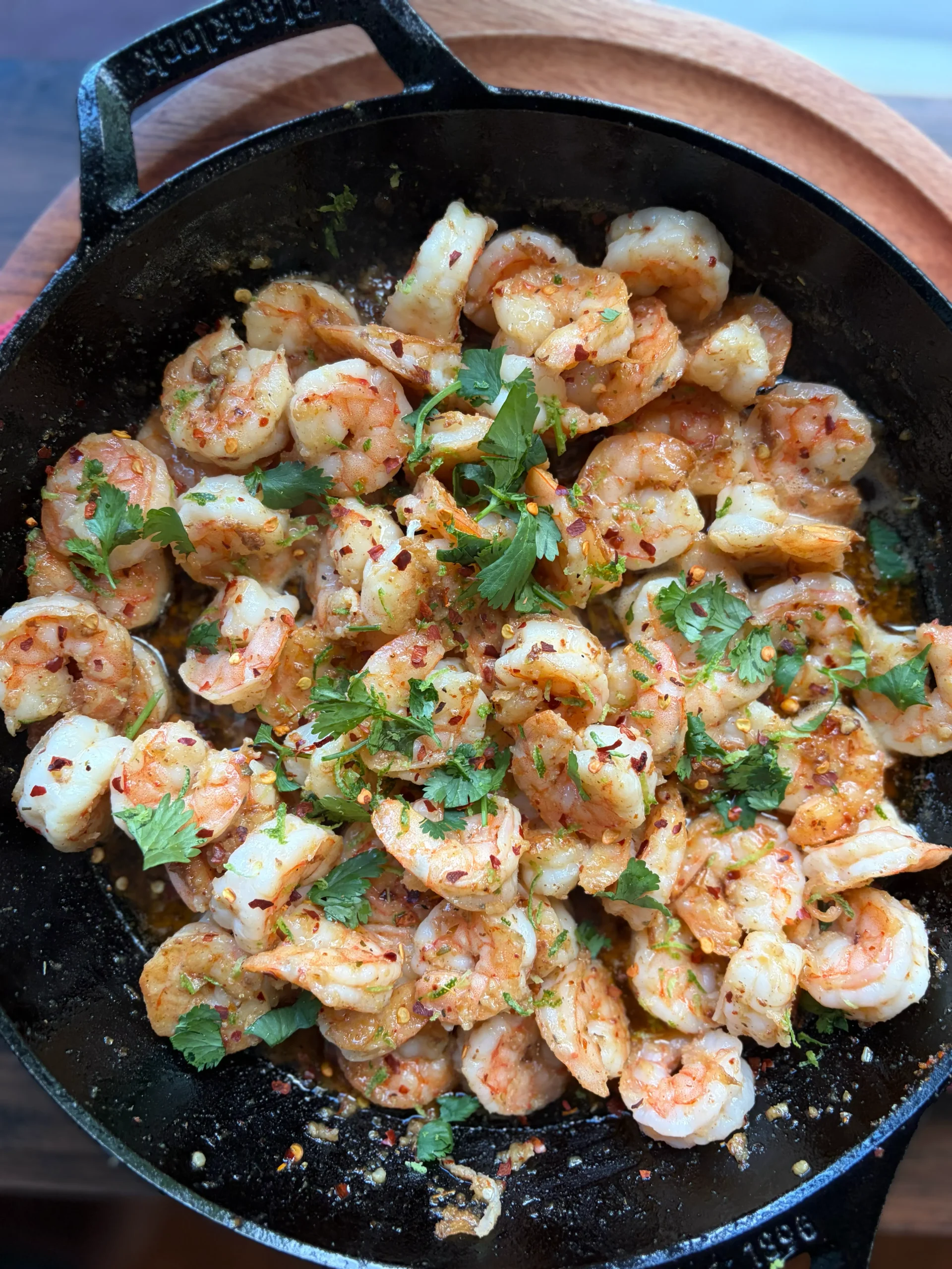 Shrimp cooked in a cast iron skillet in a butter sauce. Sprinkled with cilantro and lime zest. 