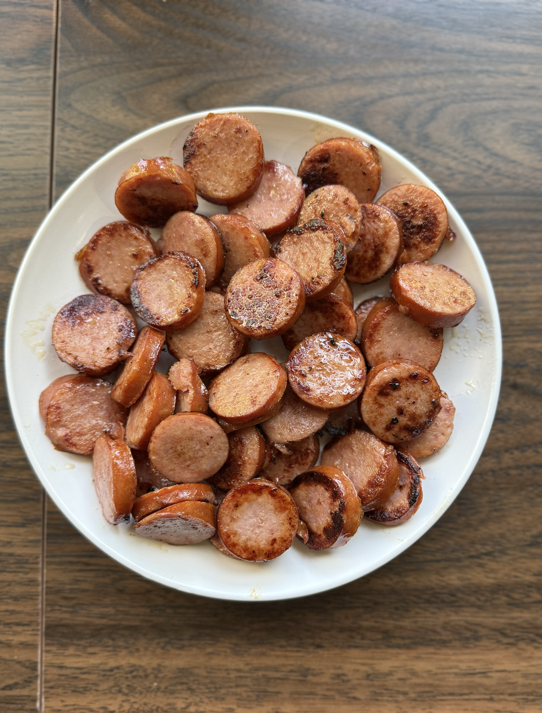 Sauted kielbasa sausage sliced on a white plate.
