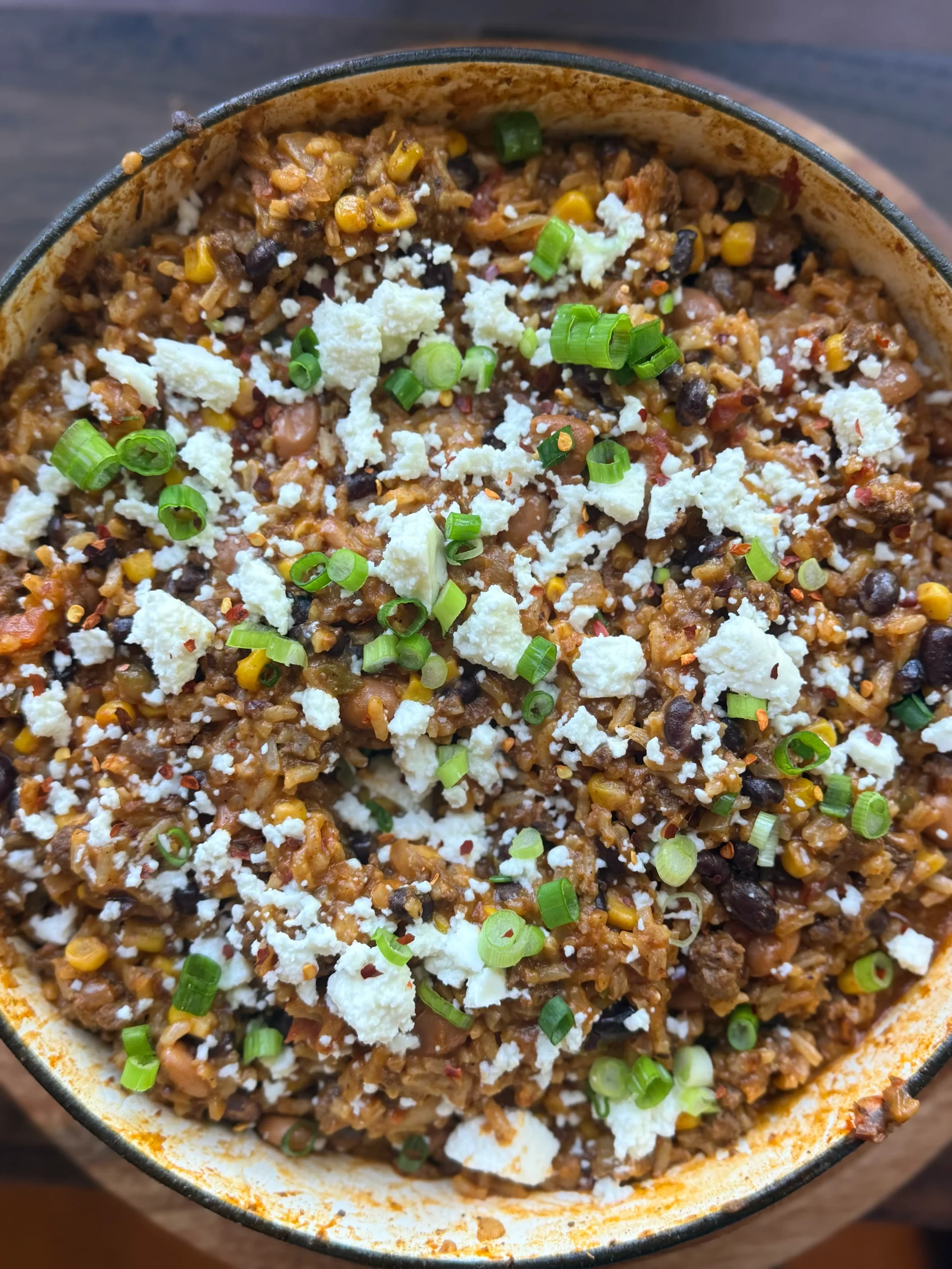 Cheesy Bean Taco Skillet after cooking topped with diced green onions and sprinkled with cheese. 