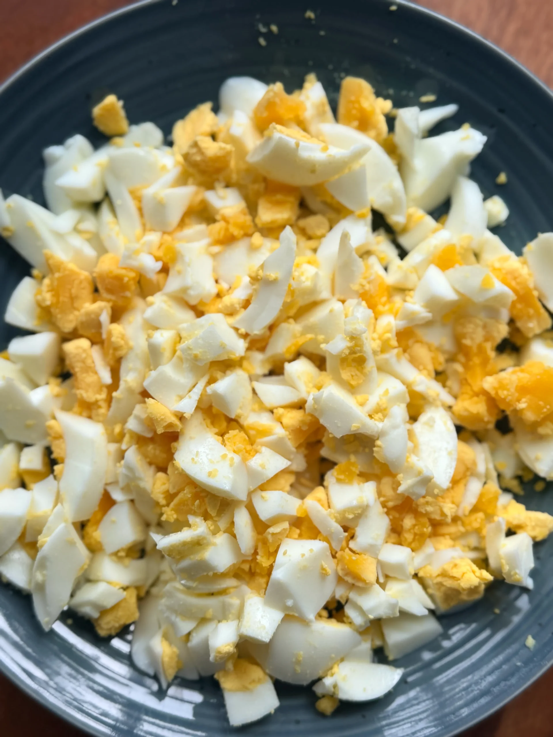 Boiled eggs chopped up on a plate.