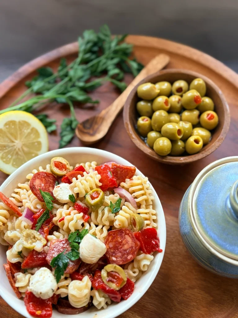 A bowl of muffuletta salad with a bowl of olives.