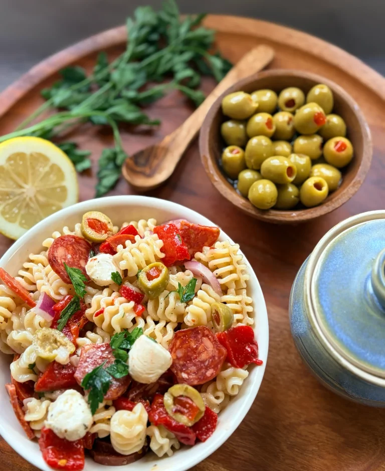 A bowl of muffuletta salad with a bowl of olives.