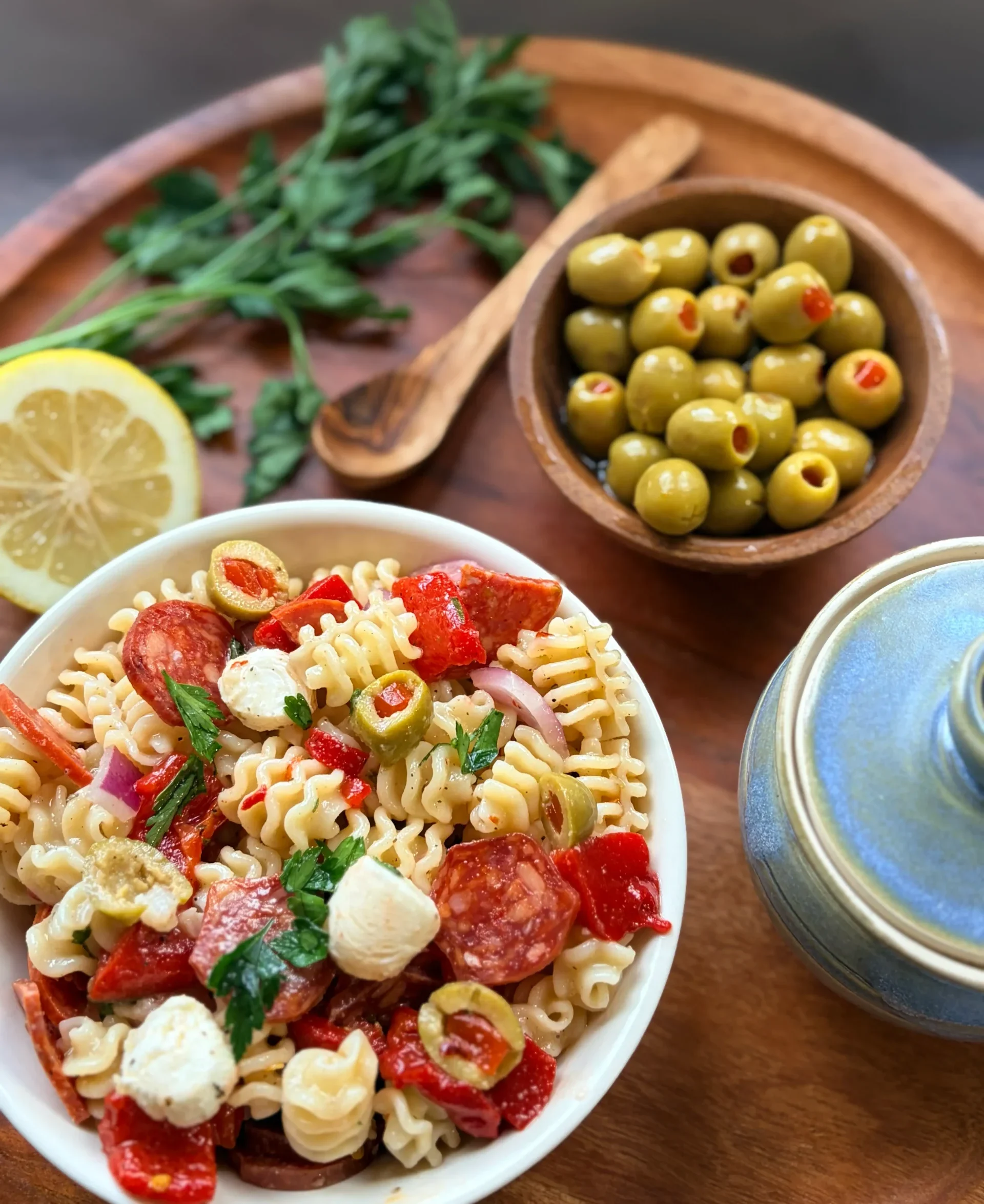 A bowl of muffuletta salad with a bowl of olives.