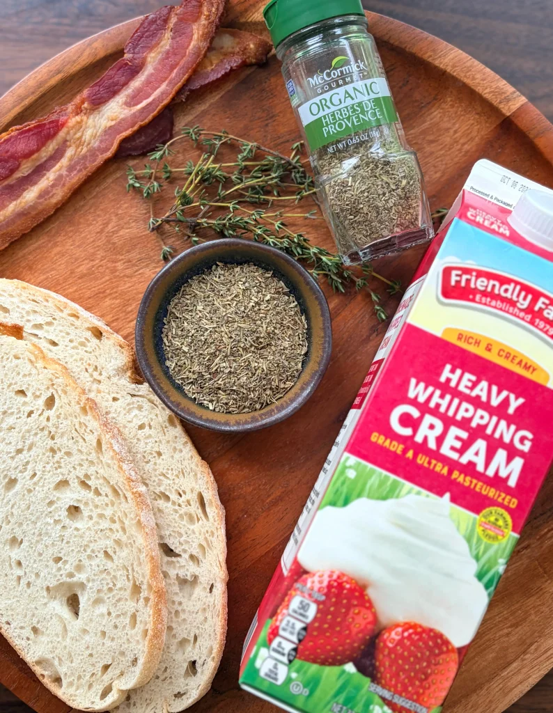 Heavy whipping cream, herbs, and sourdough bread for clam chowder recipe.