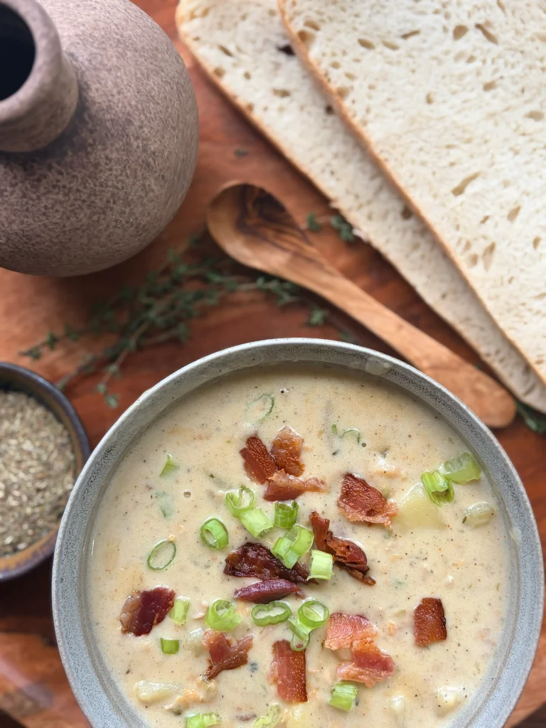 A bowl of clam chowder with 2 slices of sourdough bread for family meal.