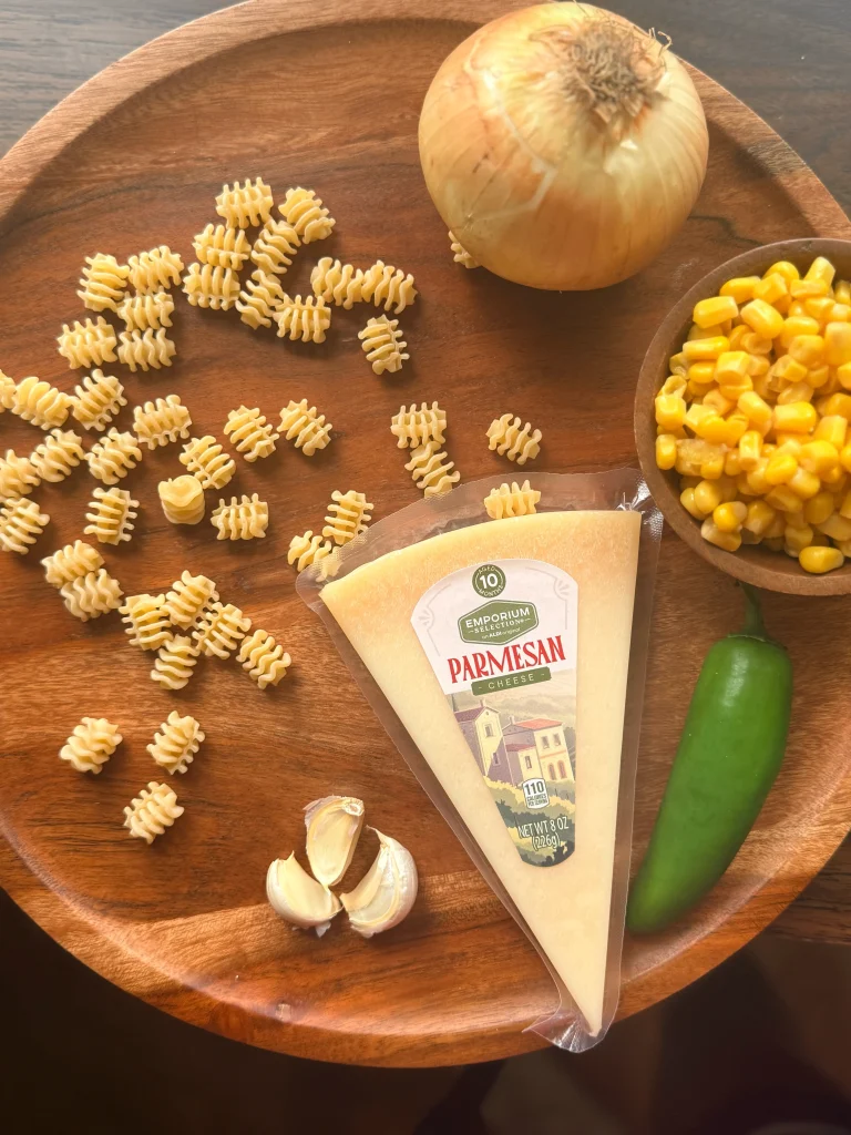 Ingredients for corn and sausage pasta. Parmesan cheese, jalapeno, onion, corn, and fresh pasta.