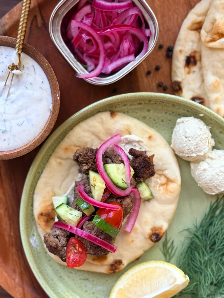 Greek lamb pitas with whipped feta and pickled onions for dinner. Lemon slices on the side for squeezing and fresh dill.