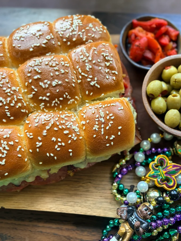 Muffuletta sliders with olives and mardi gras beads for decor.