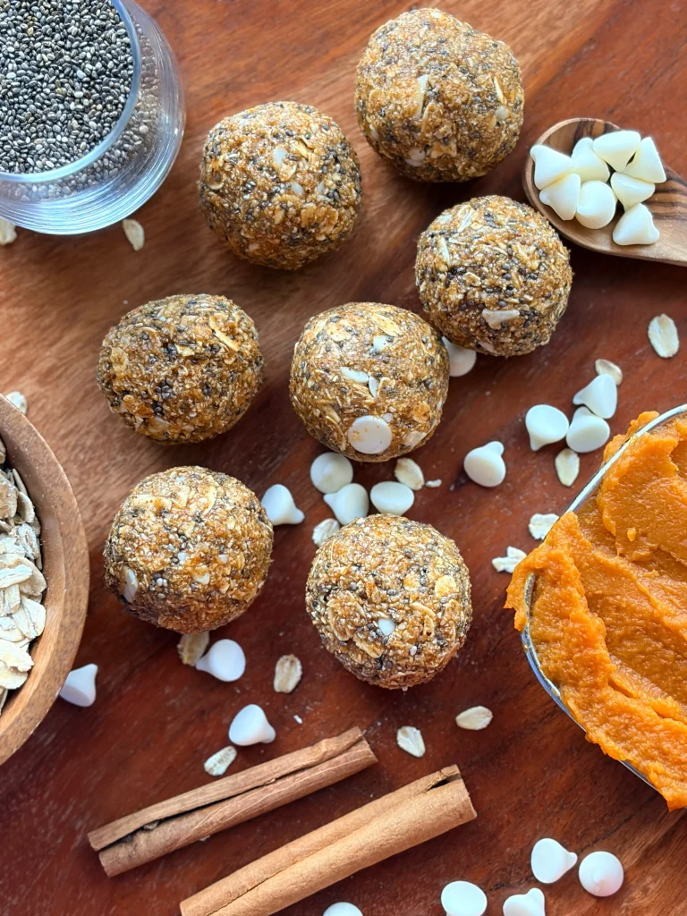 Pumpkin Pie protein balls with cinnamon sticks and pumpkin puree for decor.