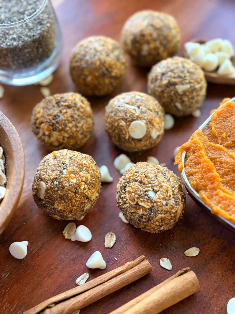 Pumpkin Pie protein balls with cinnamon sticks and pumpkin puree for decor.