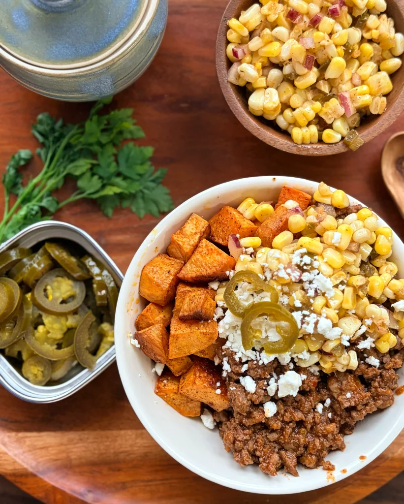 Sloppy joe sweet potato bowls with spicy sweet corn and feta cheese.