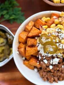 Sloppy joe sweet potato bowls with spicy sweet corn and feta cheese.